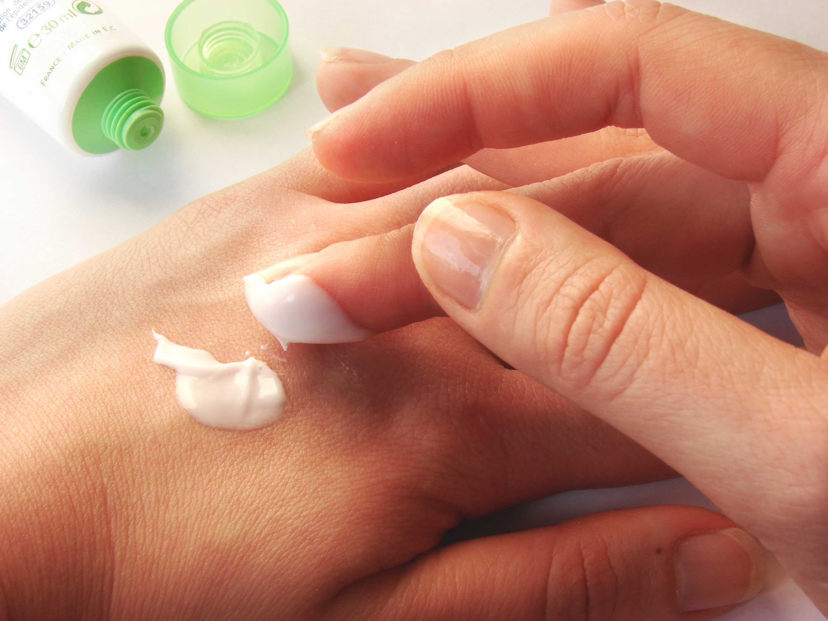 applying lotion to hands with finger