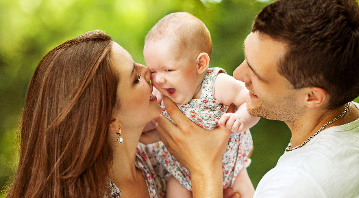 mother and father with baby daughter happy